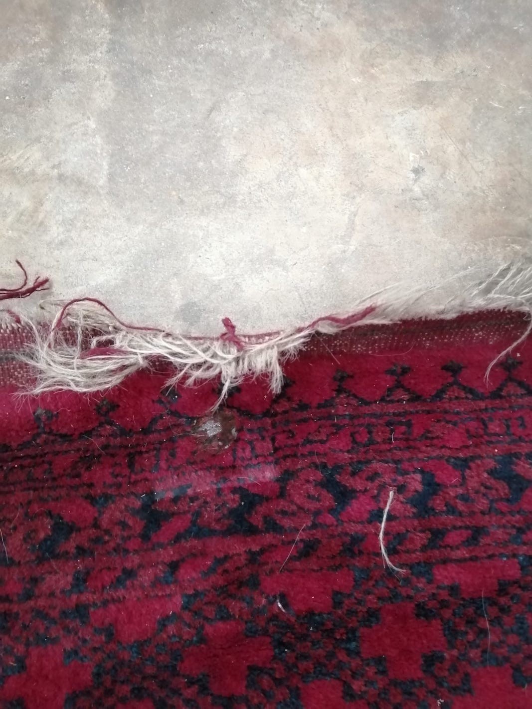 An Afghan red ground carpet (a.f.), 370 x 278cm